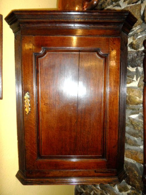 georgian oak raised panel fronted corner cupboard