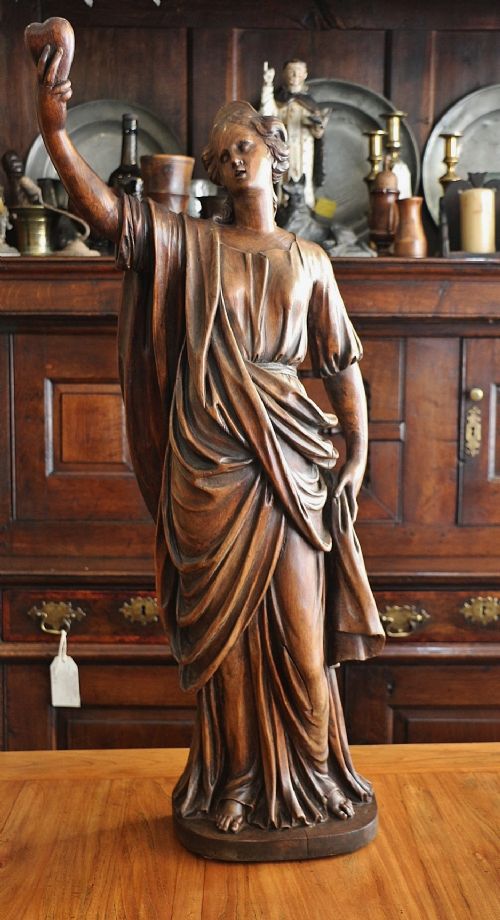 large finely carved late georgian female figure holding a heart