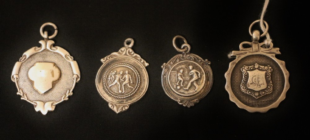 four early 20th century silver football medals